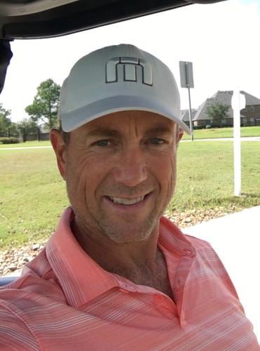 Smiling customer selfie taken from a golf cart.